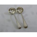 A pair of Victorian silver bead edge sauce ladles, crest engraved to the terminals, London 1873