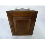 A Victorian mahogany wall mounted corner cabinet of moulded triangular section