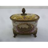 A Continental porcelain and gilded metal oval box with cover on four paw feet