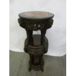 A Chinese ebonised hardwood three tier circular plant stand with inset marble top