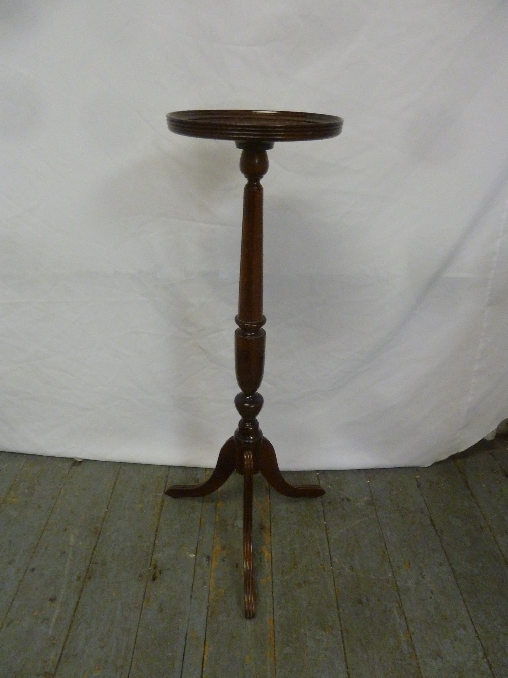 A mahogany pedestal plant stand on tripod base