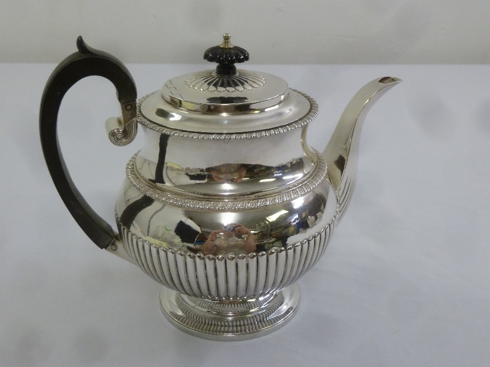 A George III silver coffee pot of fluted baluster form with gadrooned borders, raised hinged cover