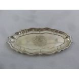 A George II silver pin tray of oval form with raised scroll border and centrally engraved coat of