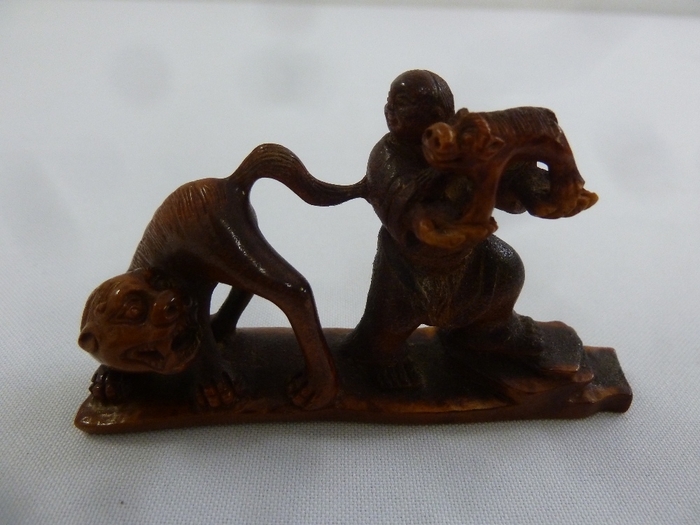 A Chinese carved deer horn figurine of a man and a tiger