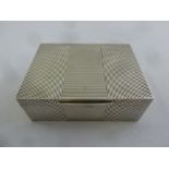 A silver rectangular cigarette box with ribbed sides and hinged cover, London 1952