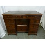 A Victorian rectangular mahogany kneehole desk with tooled leather top and brass ring handles to
