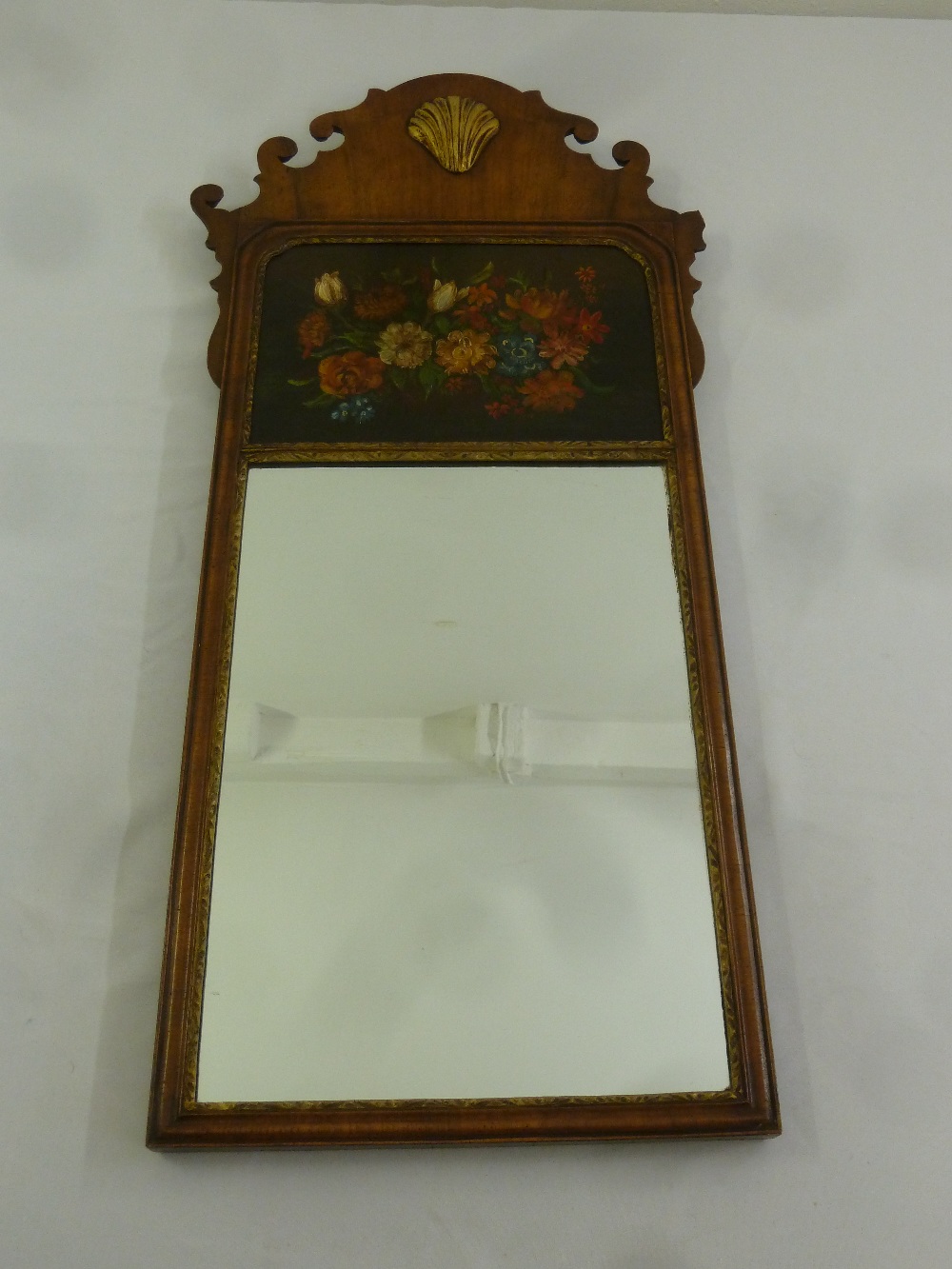 An early 20th century rectangular wall mirror with painted floral still life and applied shell