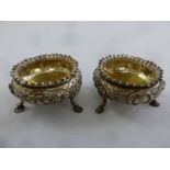 A pair of Victorian silver salts, circular, chased with flowers and leaves, gadrooned borders on