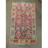 A Middle Eastern red ground carpet with repeating geometric design and border, 210 x 125cm
