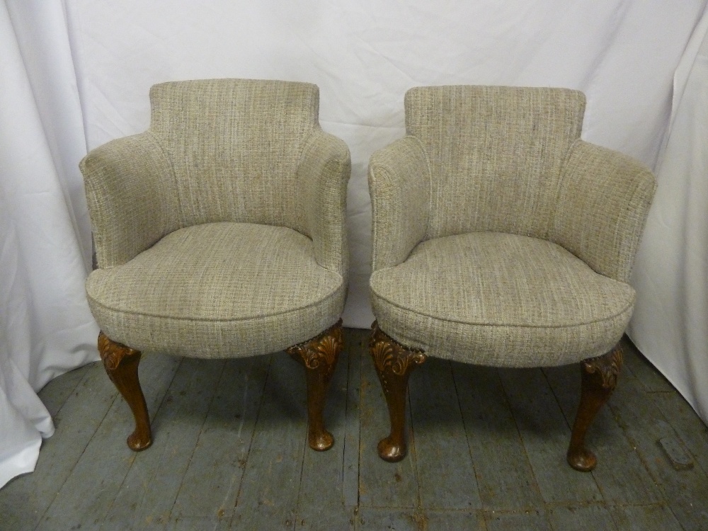 A pair of Art Deco upholstered tub chairs on cabriole legs