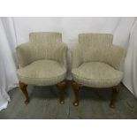 A pair of Art Deco upholstered tub chairs on cabriole legs