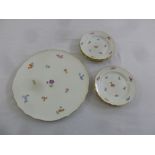 A Meissen cake stand and six matching cake plates decorated with flowers and gilded borders, marks