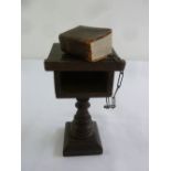 A miniature Bible on carved wooden stand