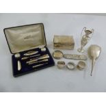 A quantity of silver to include a cased manicure set, a cigarette box and three napkin rings (9)