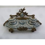 A Continental porcelain and gilded metal ink stand of shaped rectangular form on scrolling supports