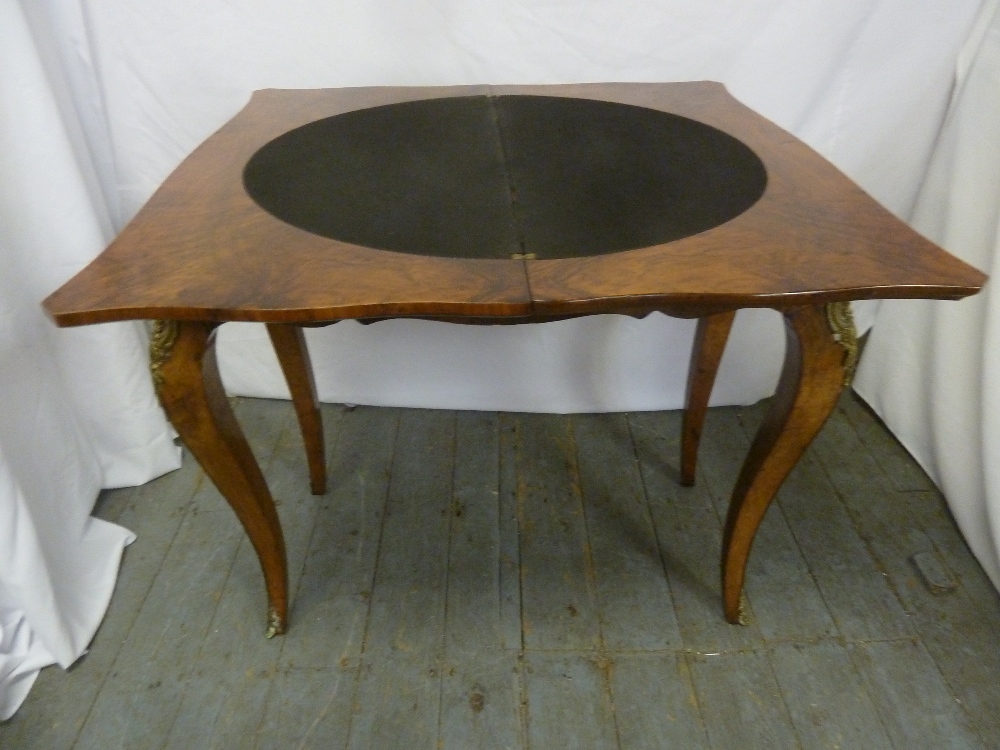 A Victorian walnut veneered games table on four cabriole legs with gilt metal mounts - Image 2 of 2