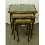 A nest of three mahogany tables with tooled leather inset tops