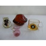 An amber glass vase, a miniature pink glass cream jug, a glass mug with scroll handle and a glass