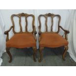 A pair of light oak occasional chairs with carved slatted backs on cabriole legs