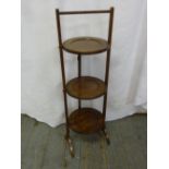 A mahogany three tier plate stand of customary form