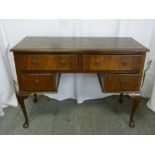 An early 20th century rectangular desk with tooled leather top with four drawers on cabriole legs