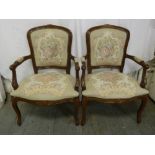 A pair of mahogany upholstered armchairs on cabriole legs