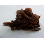 Chinese carved resin figurine of a little boy on a fish