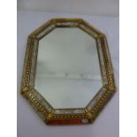 An octagonal decorative wall mirror with gilded geometric border