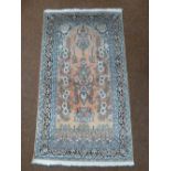 A Middle Eastern rug, pink ground with duck egg blue border and repeating floral pattern, 156 x