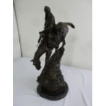 A bronze of a cowboy on a horse descending a cliff, on a raised marble plinth, copyright Remington