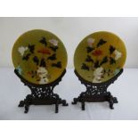 A pair of Oriental jadeite circular plaques, the floral design inset with semi-precious stones on