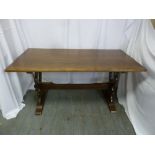 A rectangular oak dining table on side legs with cross bar stretcher