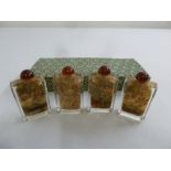 A cased set of four reverse painted glass Chinese snuff bottles