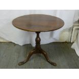 A Victorian mahogany tea table on three outswept legs