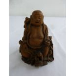An Oriental carved wooden smiling Buddha, 11cm (h)