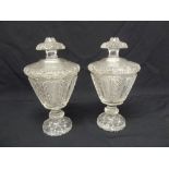 A pair of 19th century cut glass vases with raised pull off covers on raised circular bases