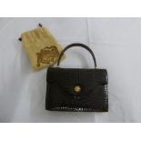 A mid 20th century crocodile skin ladies handbag to include protective cloth cover