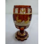 A 19th century Bohemian red glass ovoid vase decorated with gilt stags and repeating patterns