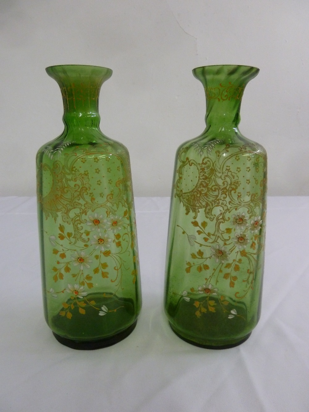 A pair of continental cylindrical green glass vases, over painted with floral sprays circa 1900