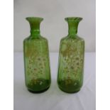 A pair of continental cylindrical green glass vases, over painted with floral sprays circa 1900