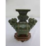 A 20th century jadeite carved vase in the form of mythical animals on carved hardwood base