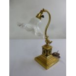 A brass decorative desk lamp, circa 1900 with glass shade