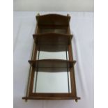 A Victorian rectangular brass and mahogany three tier wall hanging shelf with mirrored back