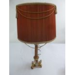 A porcelain red ground and gilded table lamp on triform base with applied sphinx to the corners