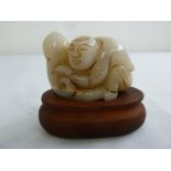 Chinese 19th century mutton fat jade figurine of a boy on a hardwood base