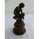 A 19th century bronze figurine of putti holding grapes on cylindrical wooden plinth, 18cm (h)