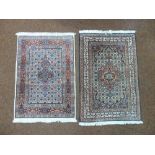 Two Middle Eastern prayer rugs with geometric repeating patterns in predominately red and blue