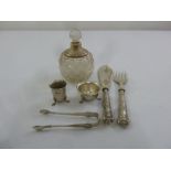 A quantity of silver to include a cut glass scent bottle with silver collar, condiments, tongs and