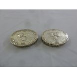 A pair of William Comyns oval dressing table boxes, the hinged covers embossed with putti, London