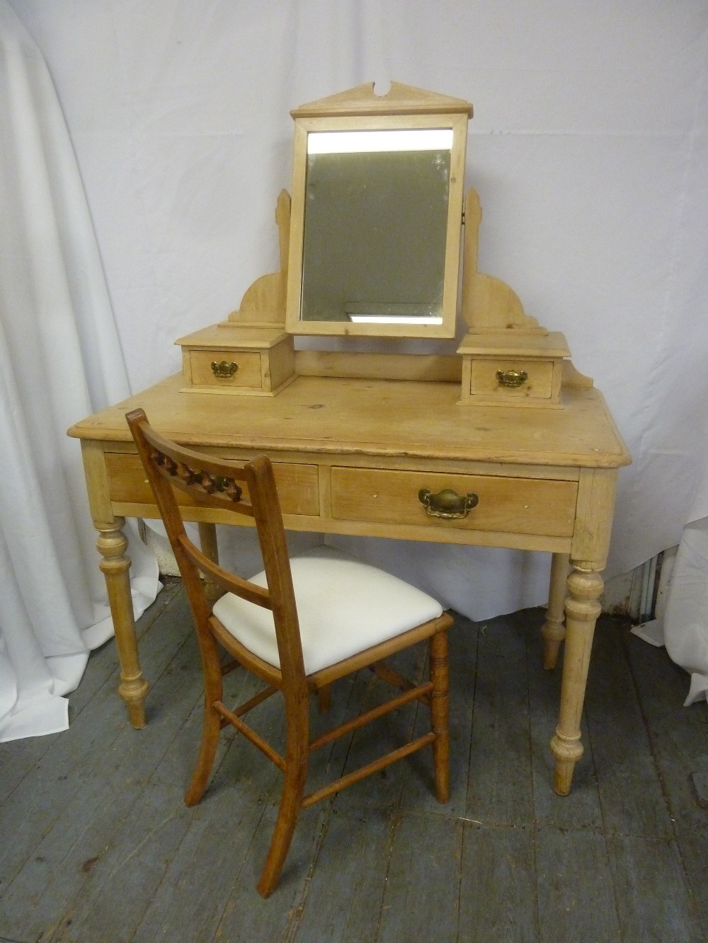 A rectangular pine dressing table with four drawers and swivel mirror on four turned legs and a